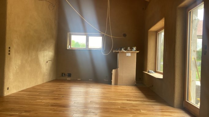 Modernes Zuhause Lichtdurchfluteter Neubau-Raum mit warmem Holzboden und Lehmputz – die perfekte Basis für ein natürliches, modernes Zuhause.
